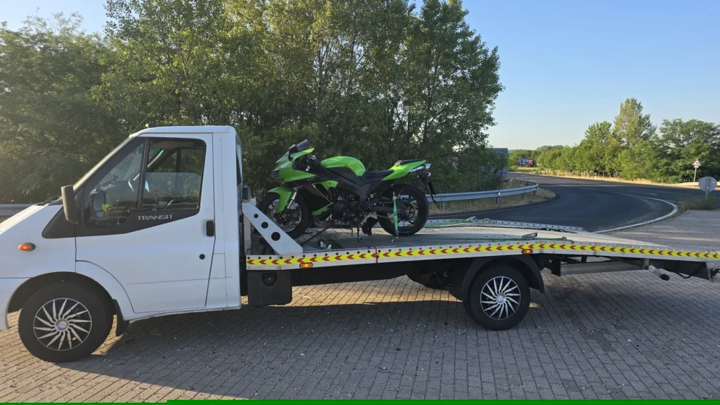 Zöld Kawasaki Ninja motor rögzítve a mentőautó platóján