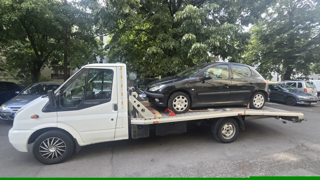 Fekete Peugeot 206 a mentőautó platóján